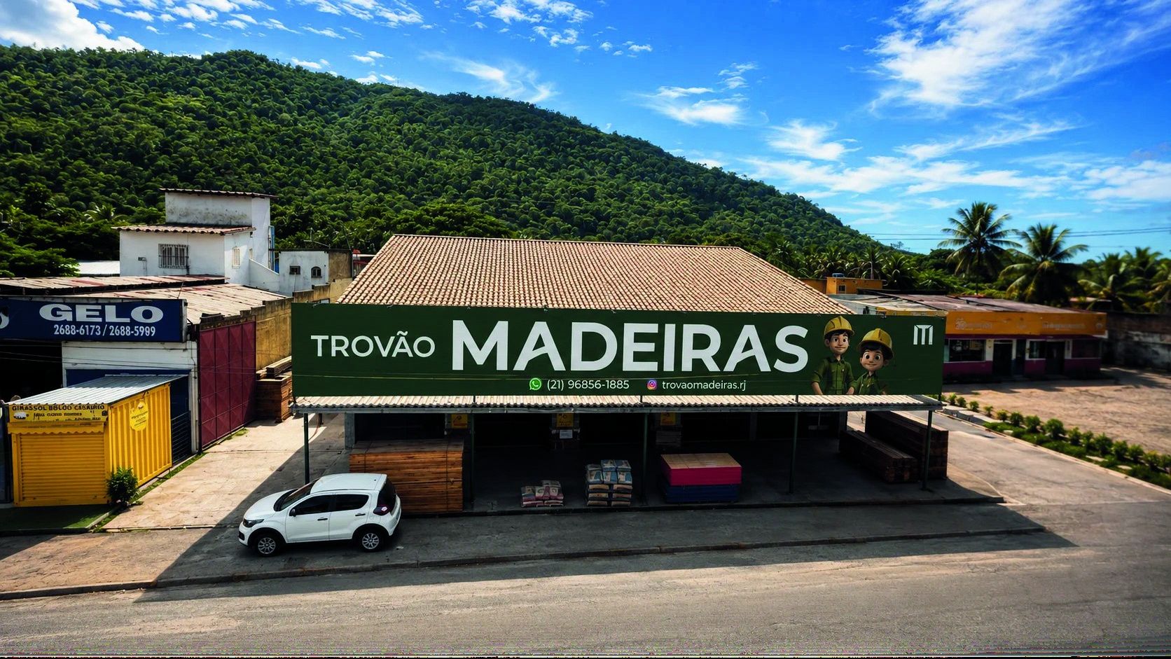Fachada da Filial da Trovão Madeiras na Rodovia Rio-Santos, com o letreiro verde e o morro ao fundo