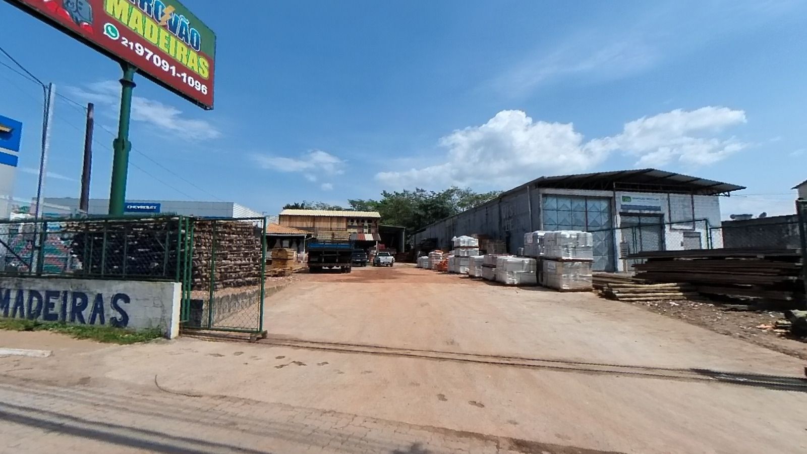 Entrada da Trovão Madeiras vista da rua, com o letreiro e o pátio ao fundo
